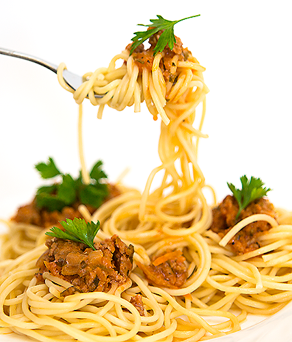 Спагетти болоньезе:

    250-300 г. спагетти
    500 г. мясного фарша. 
    1 головка лука репчатого
    1 морковка
    3 зубчика чеснока
    50 мл. сухого красного вина
    250 грамм томатов 
    50 мл. сливки
    3 столовые ложки оливкового или любого другого растительного масла;
    75 грамм тертого сыра. Где-то по 15 грамм на одну порцию спагетти с фаршем болоньезе;
    петрушка. Подойдет и сухая и свежая;
    1 чайная ложка орегано;
    соль, специи, перец по вкусу.

Крошим мелко луковицу, морковку. Mорковь и лук, пассируем в масле на слабом огне до полуготовности. Выкладываем фарш, разделяя его на небольшие кусочки, перемешиваем.Обжариваем всю смесь около 10 минут, солим, перчим.
Прибавляем огонь, вливаем вино. Добавляем помидоры, накрываем сковороду крышкой и тушим еще минут 15-20. Кладем измельченный чеснок, вливаем сливки, нарубленную зелень, варим 5 минут.
В большую кастрюлю наливаем воду, кипятим, подсаливаем. Высыпаем спагетти и на сильном огне отвариваем их, не сильно разваривая (от 7 до 10 минут). Откидываем на дуршлаг. Раскладываем по тарелкам, сверху поливаем соусом болоньезе, при желании можно посыпать тертым сыром. ☂ JАNЕ ☂