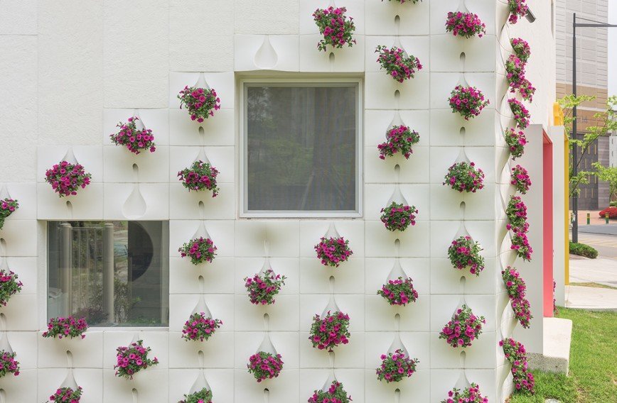 Фасад дома со встроенными цветочными горшками