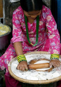 Непальская девочка готовит лепешки
