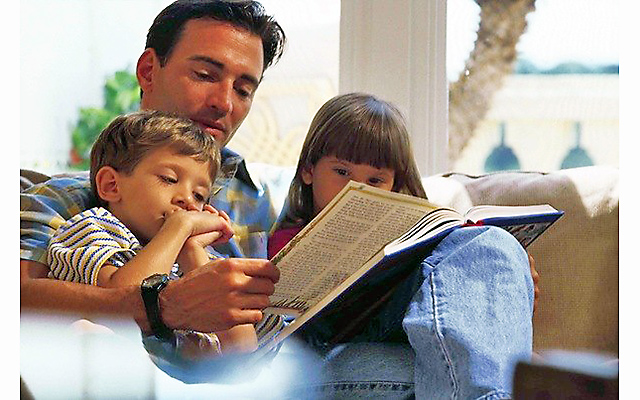 Ребенок читает Библию с родителями