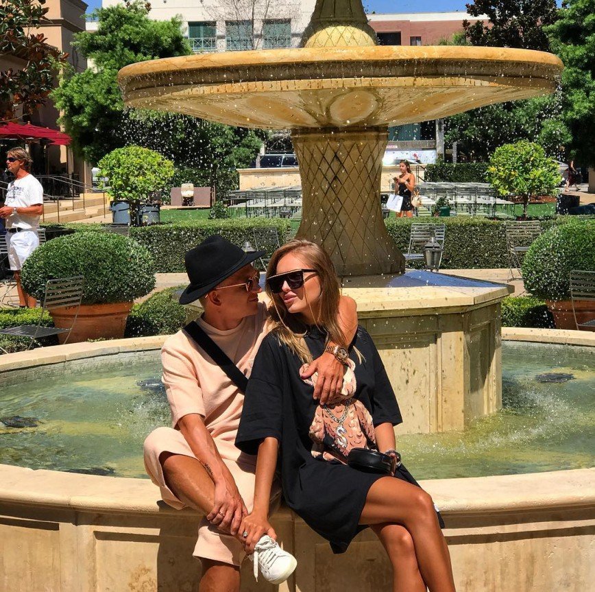 Загорелые Ханна с супругом присели на фонтан в Лос-Анджелесе