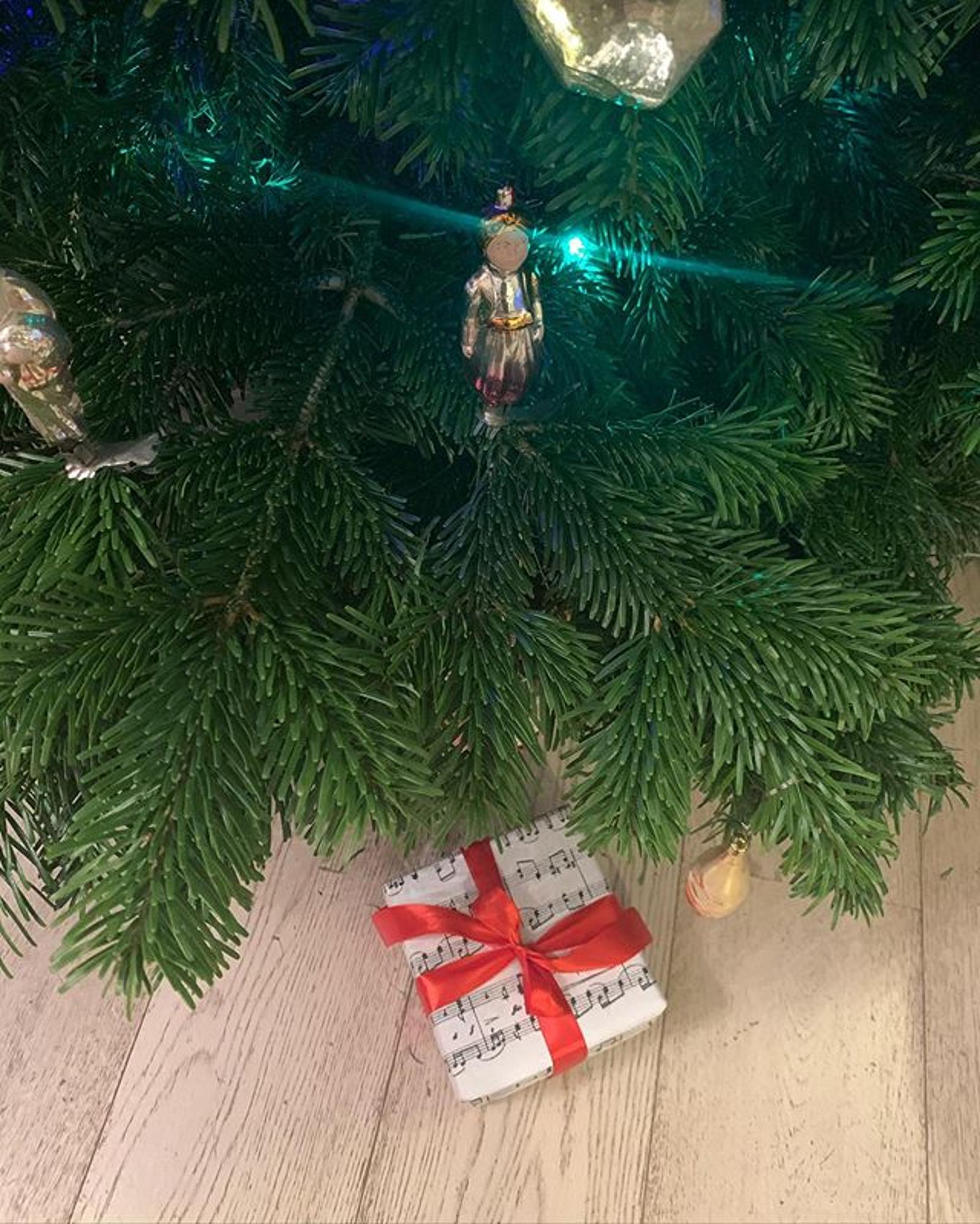 Фотография елки и подарка из микроблога Эвелины Хромченко